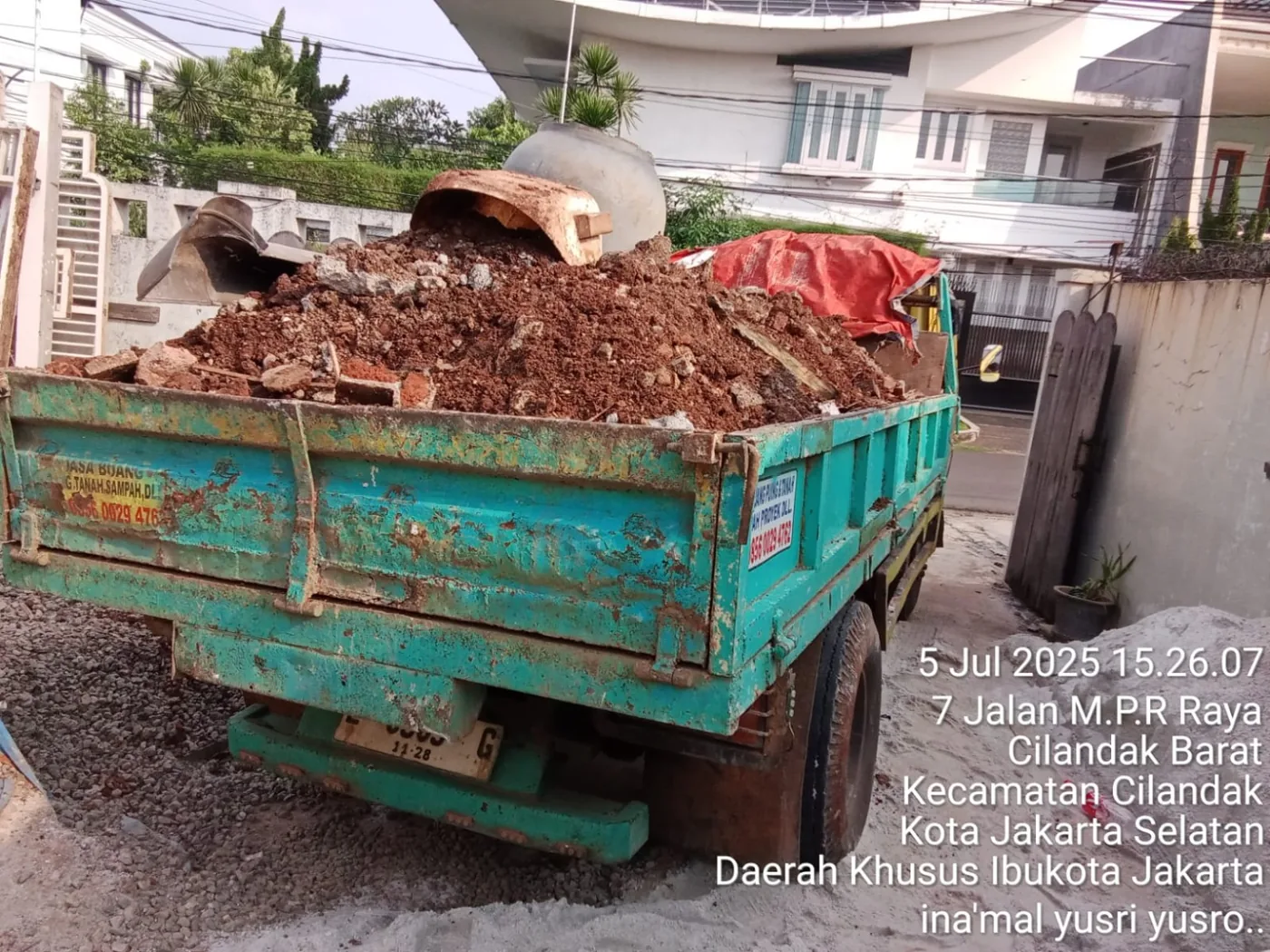 Dump truck menurunkan tanah merah
